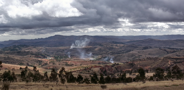 à l'horizon le massif Andringitra la fumée révèle la fabrication du charbon de bois 